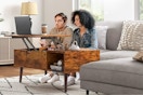 edx coffee table (lifestyle image) two people sitting on couch using it for a laptop