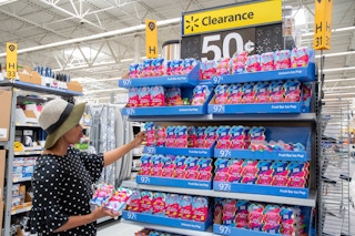 woman at a Walmart endcap picking up Cool Gear ice pop makers off the shelf that says Clearance 50 cents. 