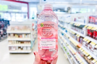 hand holding bottle of micellar water in store beauty aisle