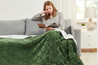 Woman sitting on couch with Sherpa Throw Blanket over her