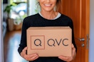 a woman holding a QVC box in her doorway