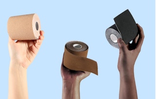 Hands holding up boob tape rolls