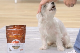 someone giving a dog the Fruitables Skinny Mini Dog Treats