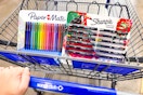 person pushing a cart with paper mate flair pens and sharpie creative markers in it