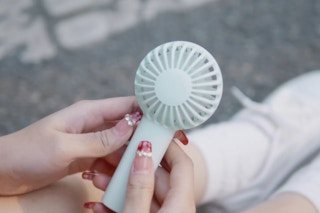 someone holding a portable handheld fan