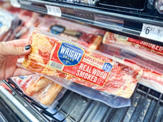 hand holding a pack of wright brand bacon in walmart aisle