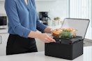 a woman using a heated lunch bag