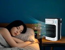 a air conditioner on a table next to a person on a bed