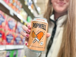 hand holding a can of popwell soda