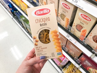 hand holding a box of barilla chickpea pasta in front of a target shelf