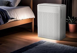 an air purifier next to a bed