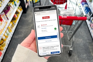 hand holding smartphone with coupon on screen