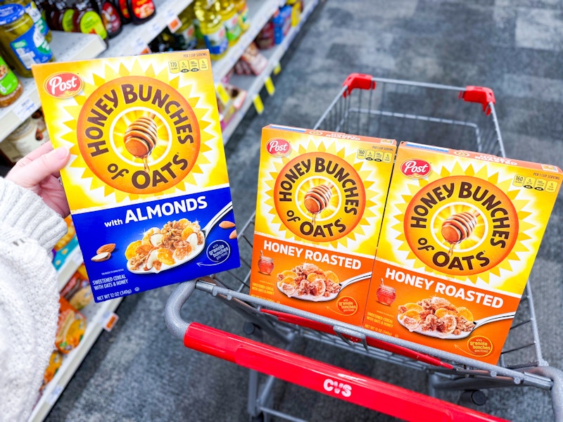 3 boxes of post honey bunches of oats cereal in a cvs cart