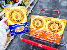 3 boxes of post honey bunches of oats cereal in a cvs cart