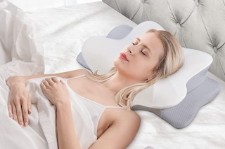 a woman laying on a cervical neck pillow