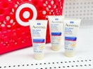 3 aveeno skin relief healing ointments in front of a target basket