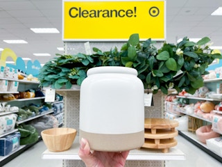 hand holding a magnolia utensil holder in front of clearance sign at target