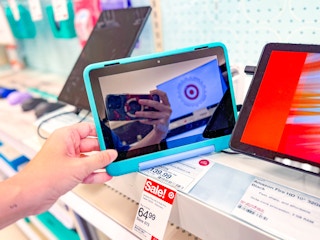 hand grabbing an amazon kids' tablet off a target shelf