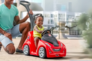 Lifestyle image of Step 2  Push-Around Buggy being used by a dad pushing around his daughter
