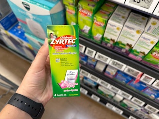 hand holding a bottle of childrens zyrtec in walmart aisle