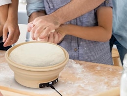 an electric sourdough starter with dough on a kitchen counter