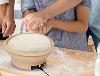 an electric sourdough starter with dough on a kitchen counter