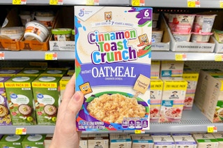 box of cinnamon toast crunch oatmeal held in front of oatmeal shelves at walmart