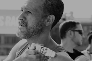 a person putting Icy Hot on their shoulders