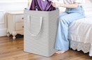 a person pulling clothes out of a laundry basket