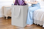 a person pulling clothes out of a laundry basket