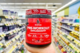 person holding a jar of pre-workout in an aisle