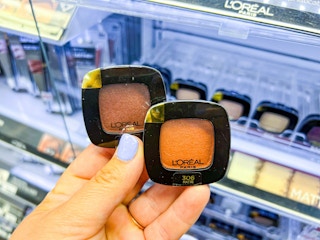 hand holding two loreal eyeshadow monos