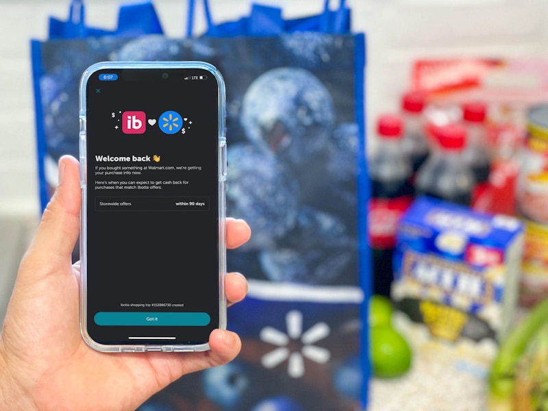 hand holding cellphone with ibotta in front of groceries