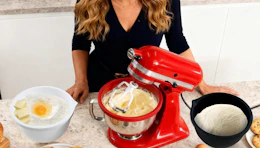 a mixer mixing batter ib a silicone bowl on a kitchen counter