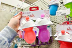hand holding a munchkin sippy cup set in front of a target shelf