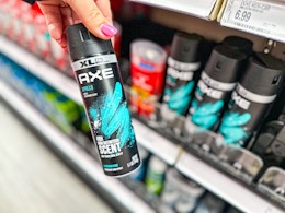 hand holding an axe deodorant body spray in front of target shelves
