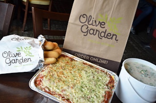 An Olive Garden family to go meal on a table.