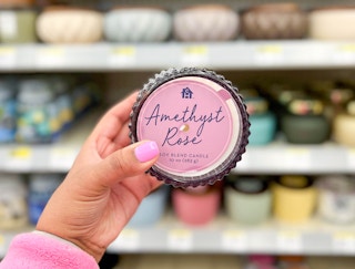 hand holding a Complete Home Amethyst Rose candle