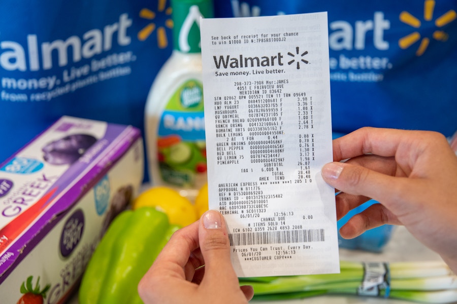 A walmart grocery receipt in front of groceries on a counter.