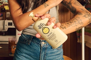 woman holding body lotion in front of body