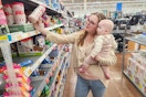 a woman shopping at walmart holding a baby