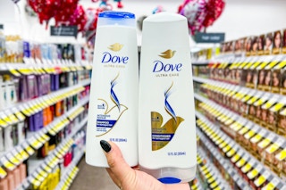 hand holding two bottles of dove shampoo and conditioner in a store aisle