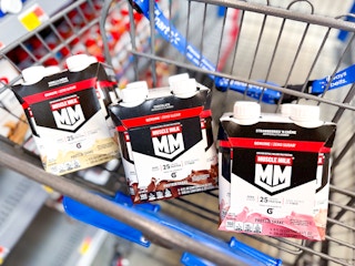 vanilla, chocolate, and strawberry Muscle Milk packs in a Walmart cart