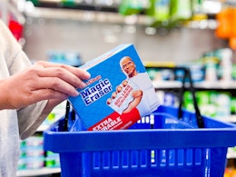 hand holding a pack of mr clean erasers over walmart hand cart