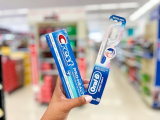 hand holding crest and oral-b