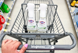 hand pushing shopping cart with two bottles of Clorox disinfecting spray mist