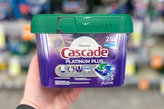 hand holding tub of dishwasher pods