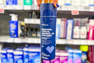 person holding a bottle of men's minoxidil hair growth