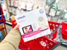 hand holding a vtech video monitor in front of a target cart