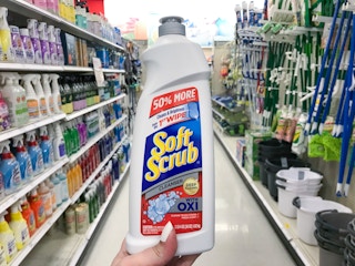 hand holding a bottle of soft scrub cleanser in an aisle at target